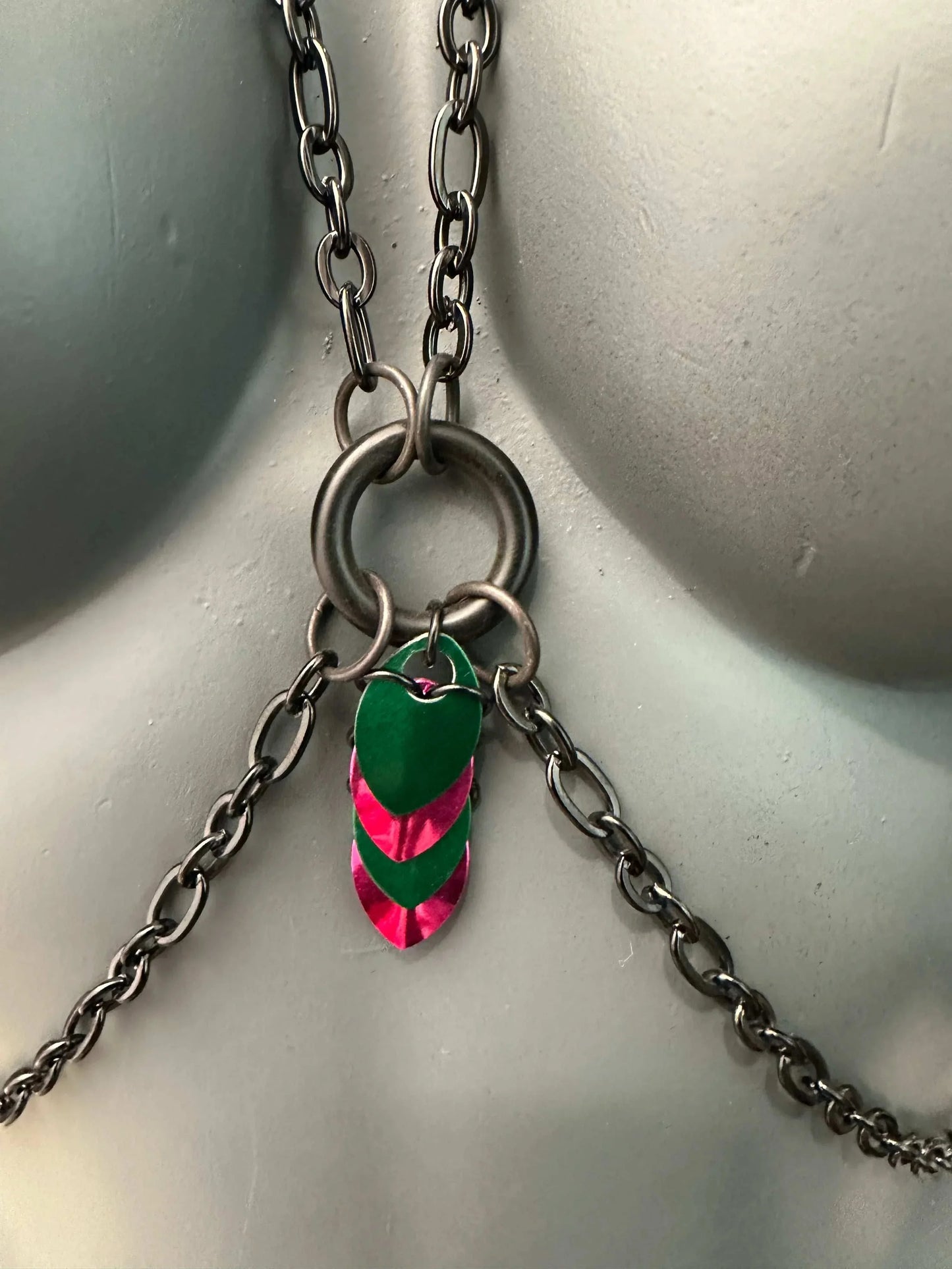 Chain necklace with silver metal links and green-pink heart-shaped charms, edgy and vibrant