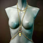 gold body chain jewelry on matte gray mannequin evokes elegance and sophistication