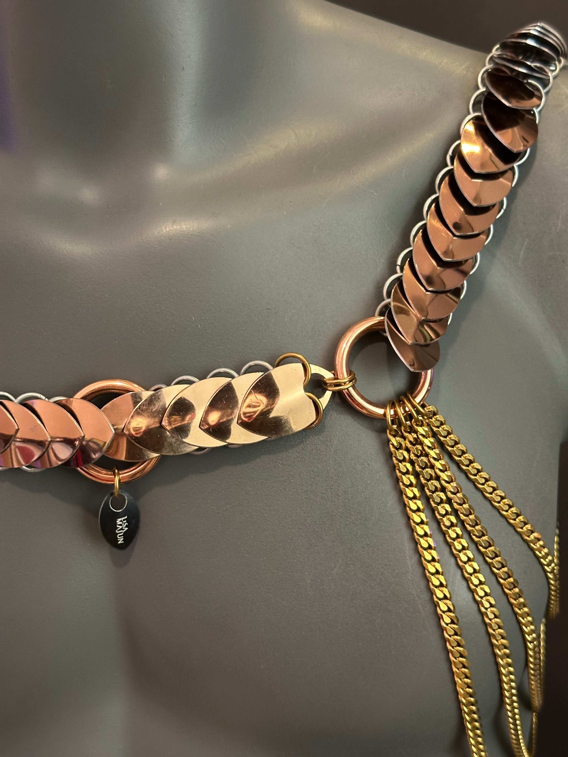 Metal necklace with rose gold and gold chains, shiny and elegant, evoking luxury and sophistication