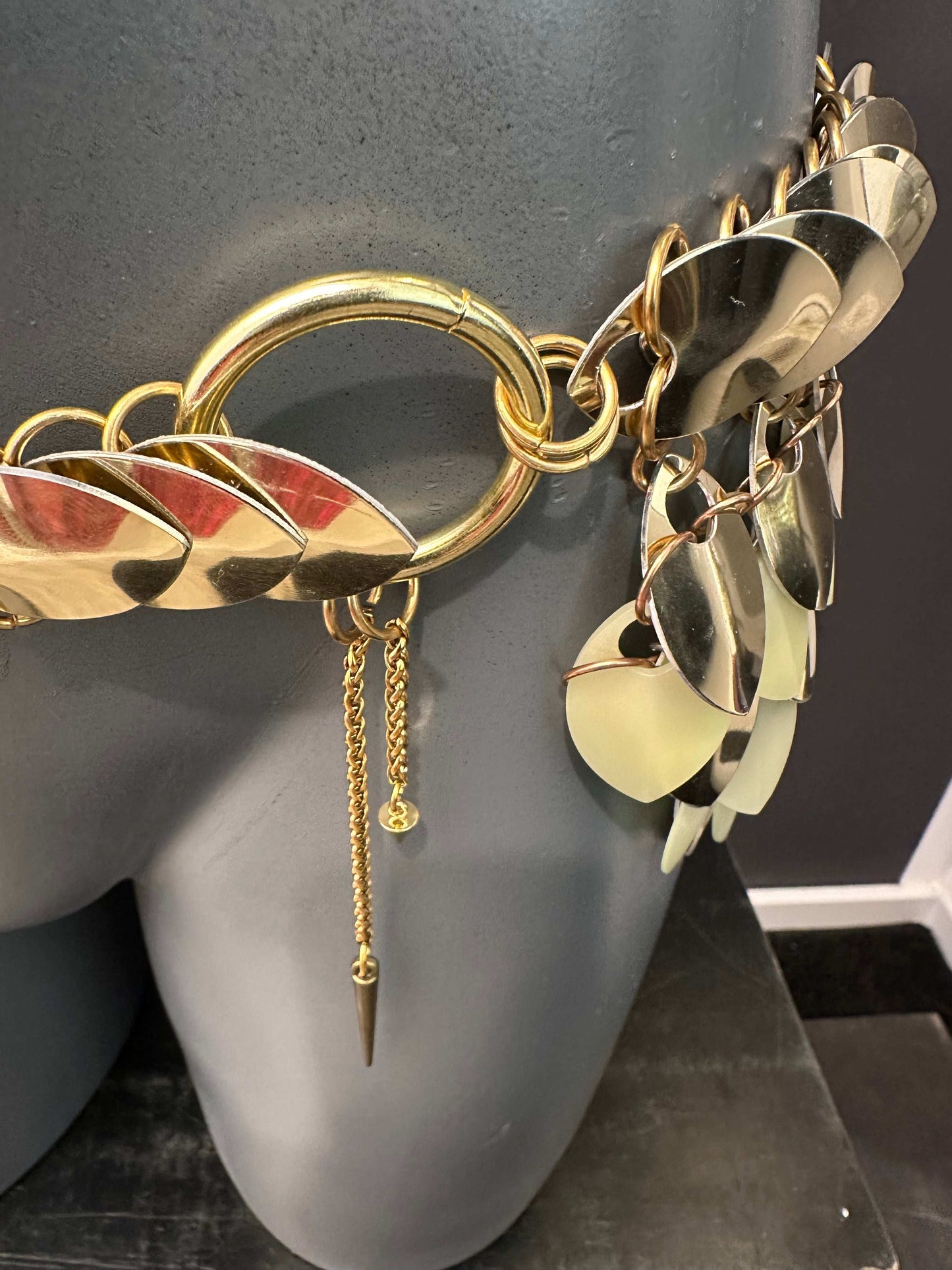 gold metal chain belt with large oval and leaf-shaped links, shiny and bold style, stylish and confident