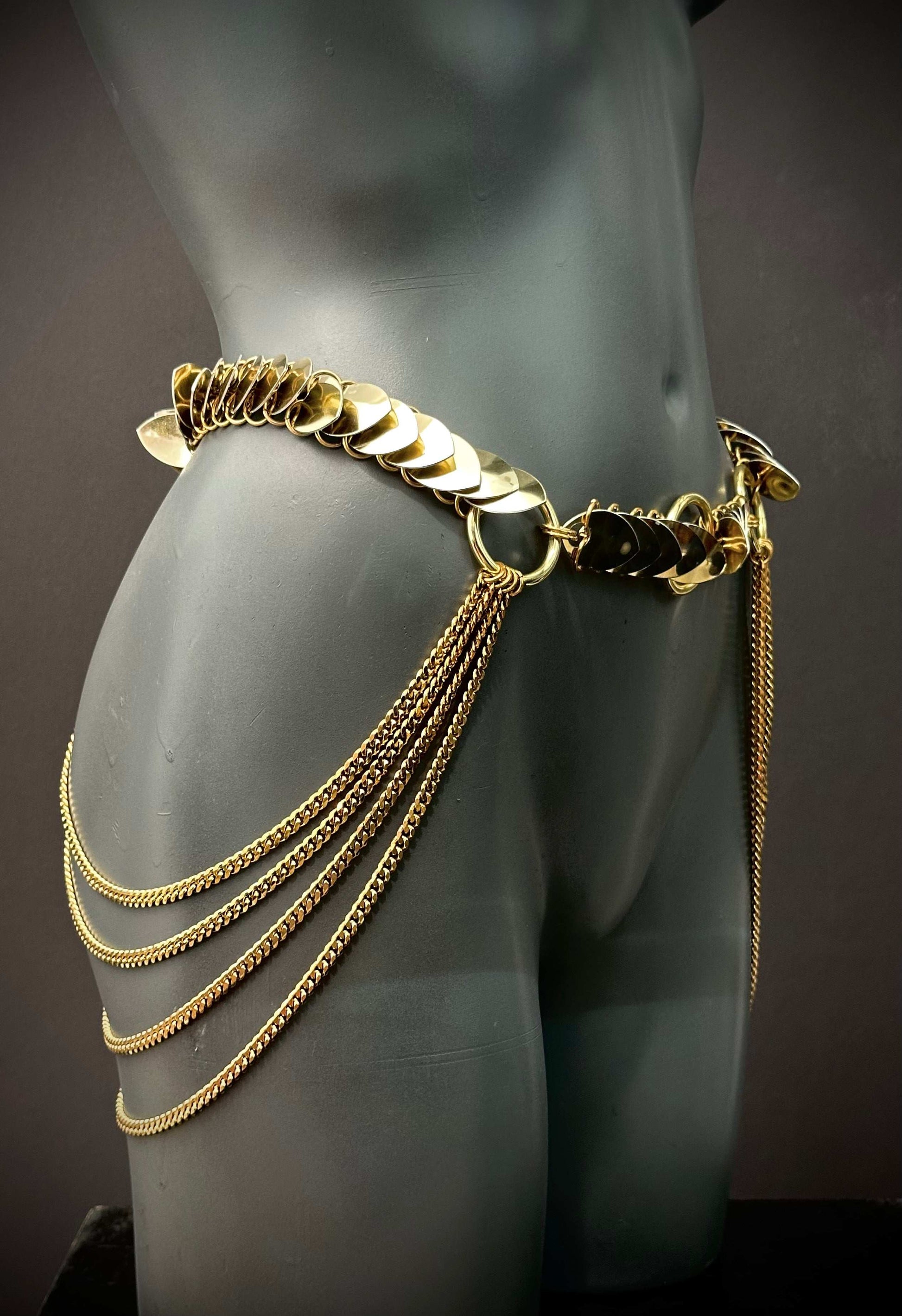 Gold metal chain belt with decorative discs and hanging chains on dark mannequin, elegant and bold