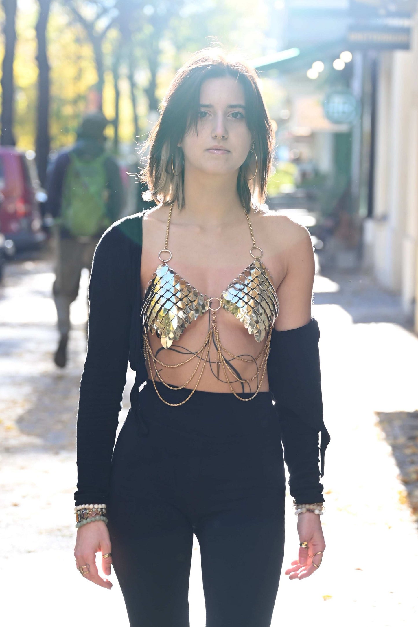 gold chain bra with black pants and sleeve, stylish fashion, confident and bold woman
