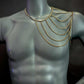 gold chain shoulder necklace on gray mannequin bust, elegant and bold fashion accessory