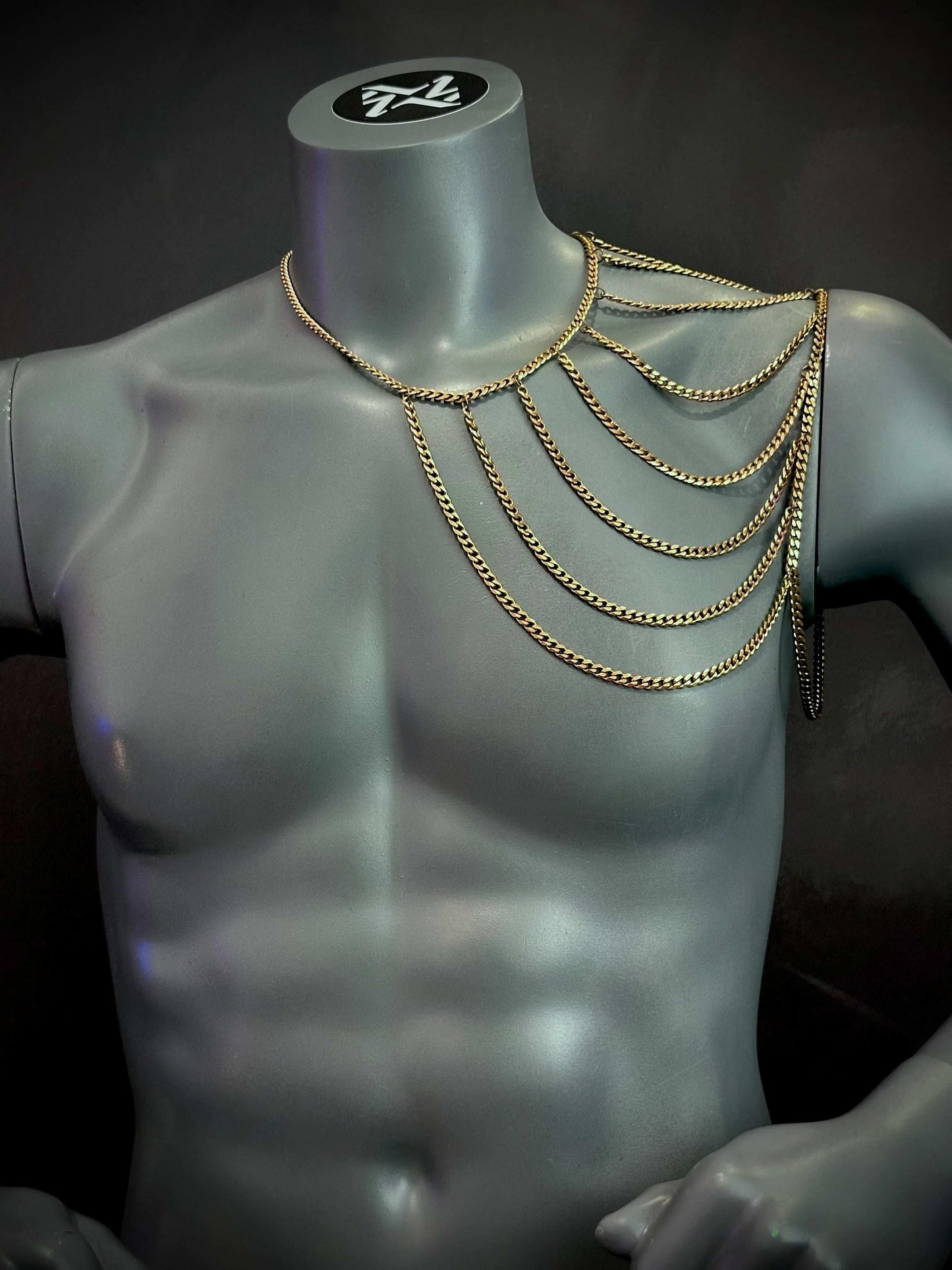gold chain shoulder necklace on gray mannequin bust, elegant and bold fashion accessory