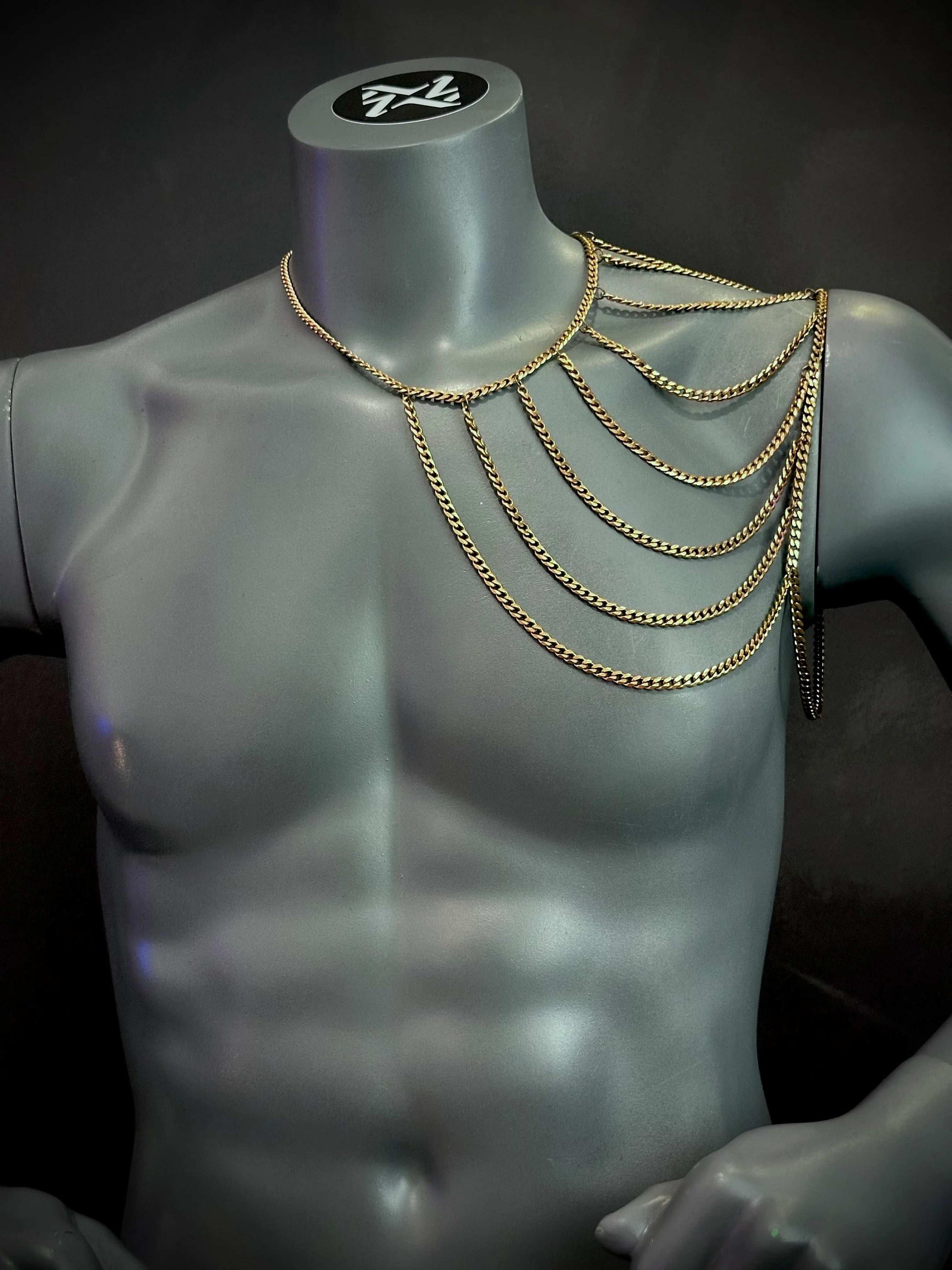 gold chain shoulder necklace on gray mannequin bust, elegant and bold fashion accessory