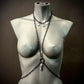 chain body harness in dark metal, edgy style on gray mannequin, bold and confident vibe