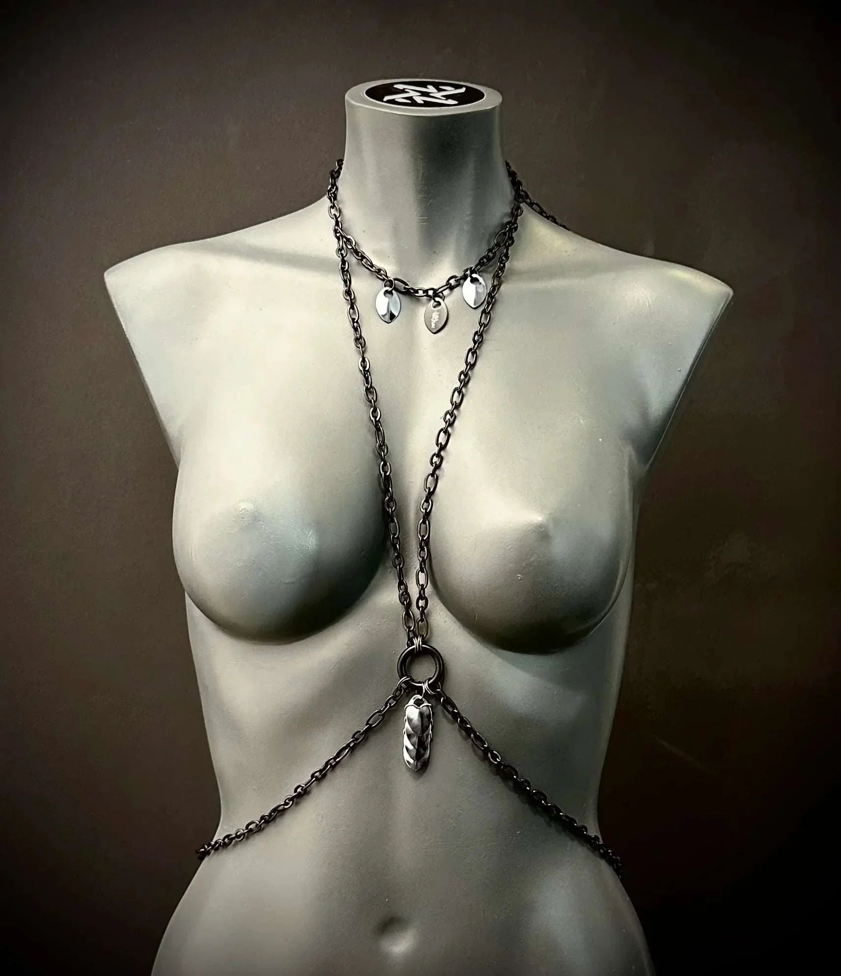 chain body harness in dark metal, edgy style on gray mannequin, bold and confident vibe