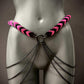 pink and black leather chain belt with black metal chains on grey mannequin, edgy and bold
