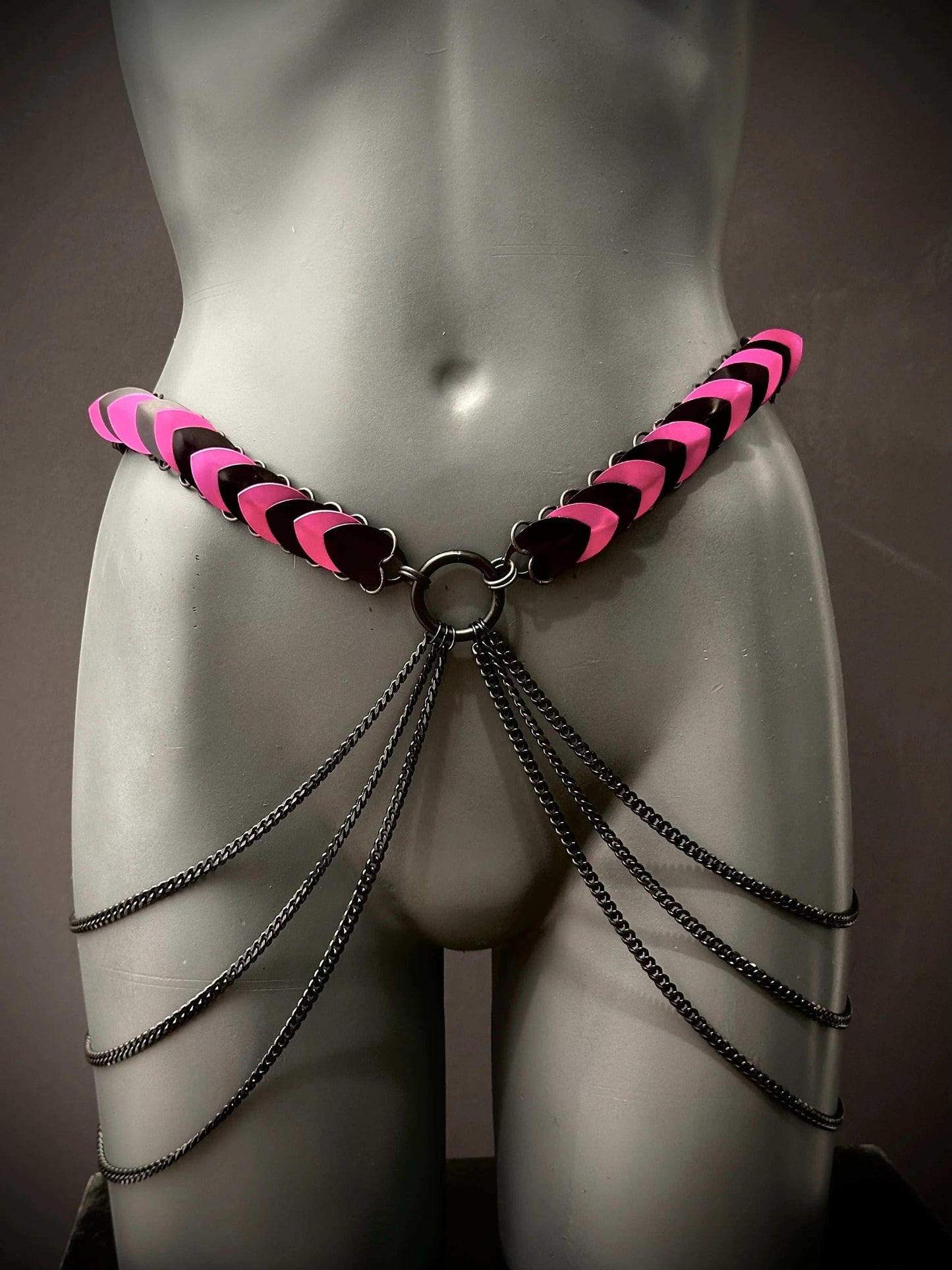 pink and black leather chain belt with black metal chains on grey mannequin, edgy and bold