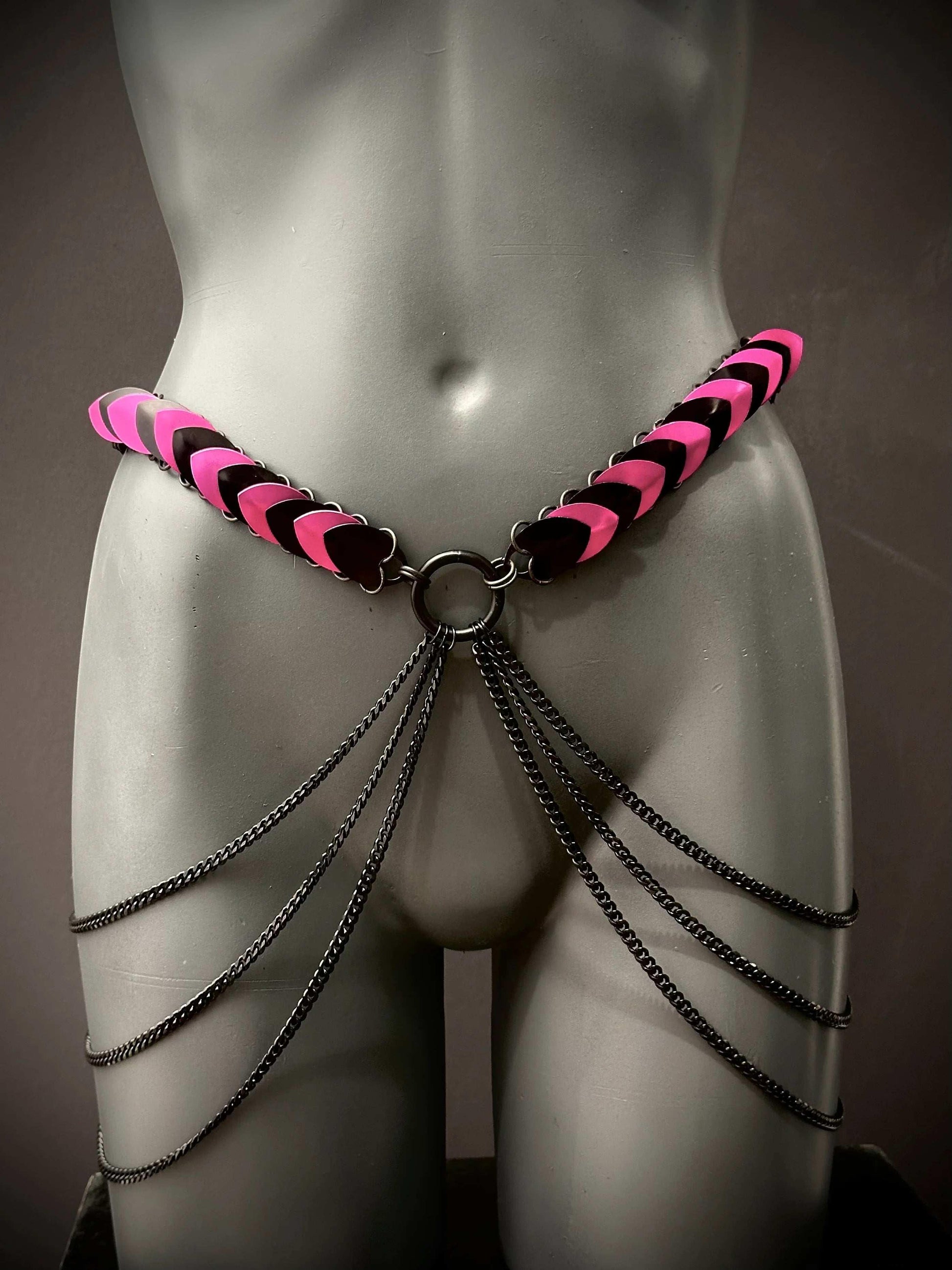 pink and black leather chain belt with black metal chains on grey mannequin, edgy and bold