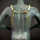 Gold metal chain body harness with long fringe on black mannequin back elegant edgy style