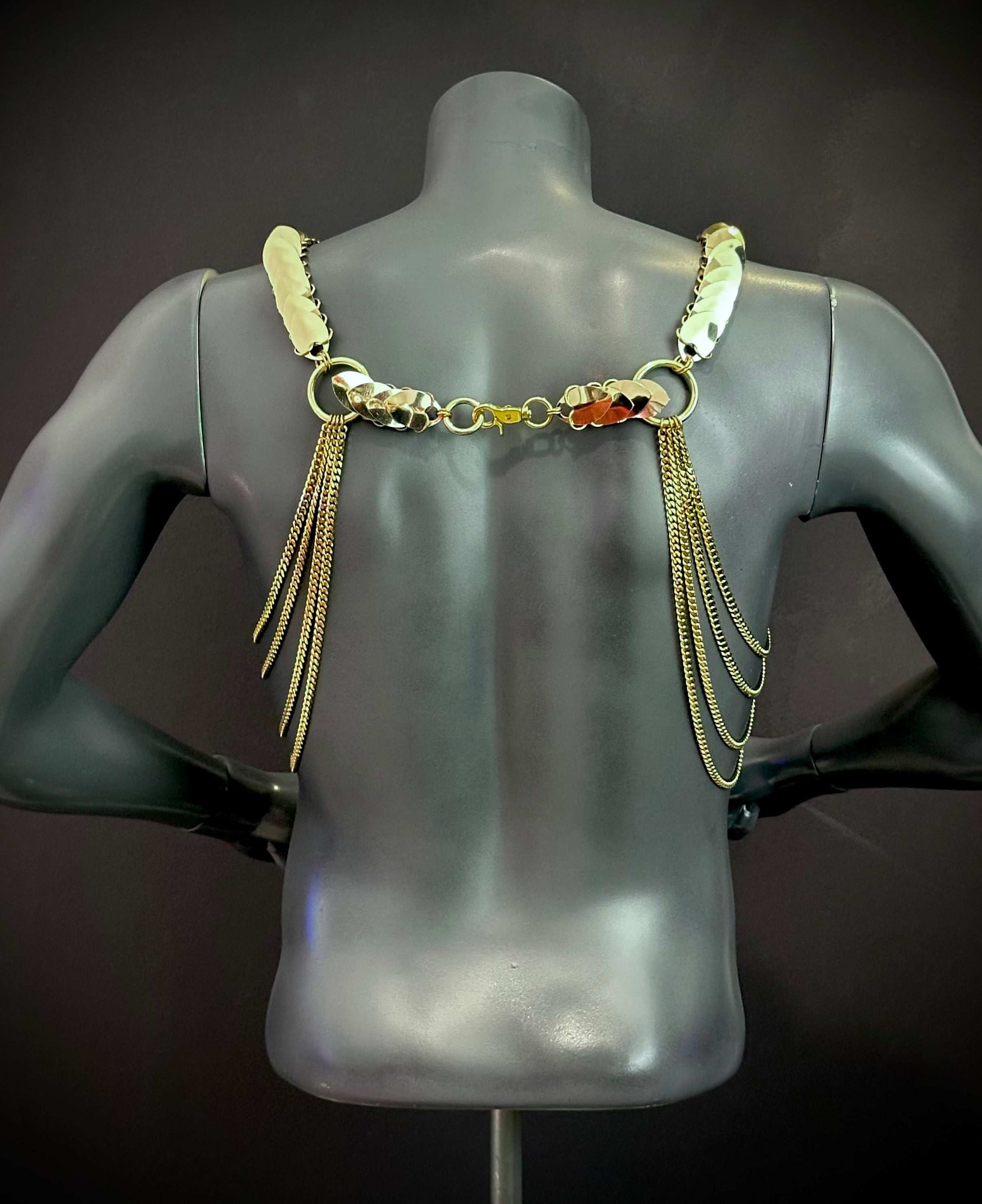 Gold metal chain body harness with long fringe on black mannequin back elegant edgy style