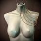 Gold chain shoulder jewelry on gray mannequin, elegant style, luxury and boldness