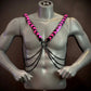 Pink and black leather harness with silver chains on gray mannequin, edgy and bold style