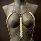 Golden body chain jewelry with green leaf accents on black mannequin, elegant and bold
