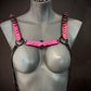 pink chain harness with black metal rings and chains on gray mannequin, edgy and bold style
