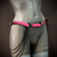 Pink scale chain belt with black metal chains on gray mannequin hips, edgy and bold fashion
